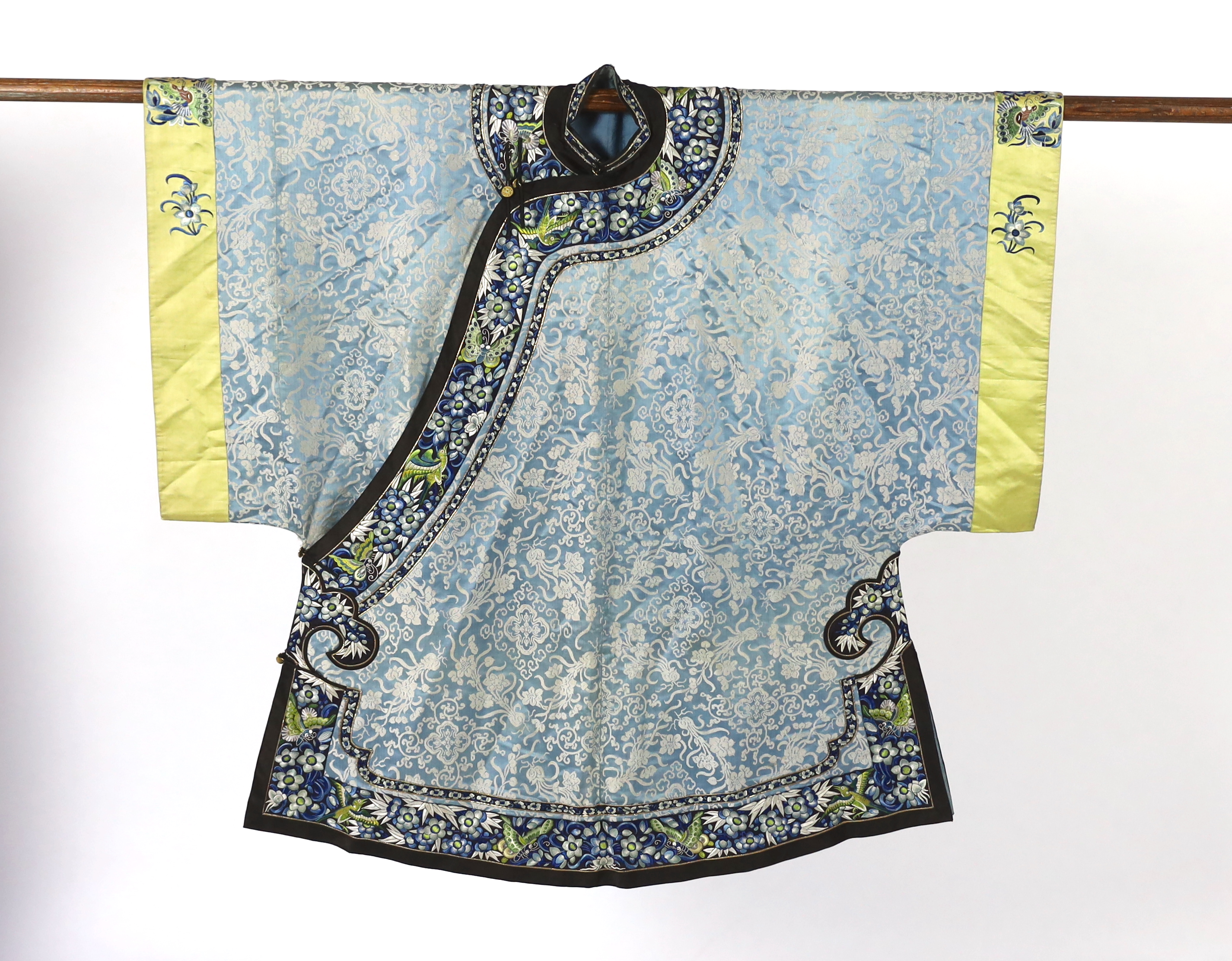 A late 19th / early 20th century silk damask robe, edged with highly ornate embroidered silk braiding, edged with fine gold and black borders, with yellow silk embroidered sleeve bands, the blue silk lining is faded in p